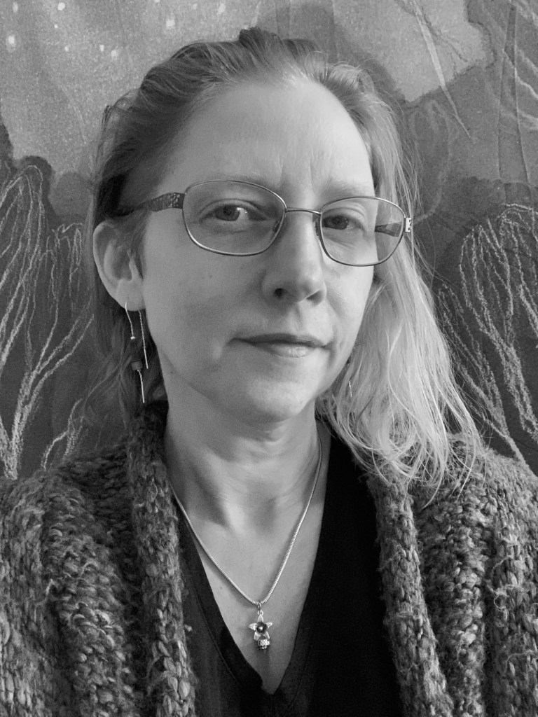 This is a headshot of the author, Sun Hesper Jansen. Sun is in front of a backdrop with various shapes behind her. Her hair is brushed back on the left side and sits at shoulder length on the right. Her eyes are facing the camera and she has a slight smile. Sun is wearing metal-frame glasses, dangling earrings, and a necklace with a star pendant. She is wearing a dark v-neck top with a knitted cardigan on top. The photo is in black and white. 